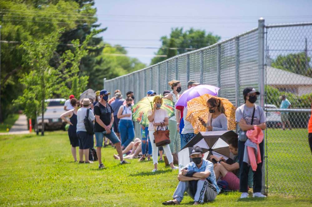 Hundreds of people queued on the outdoor pitches at the Winnipeg Soccer Federation's north complex for a chance at getting a shot of the Pfizer vaccine. (Mikaela MacKenzie / Winnipeg Free Press)
