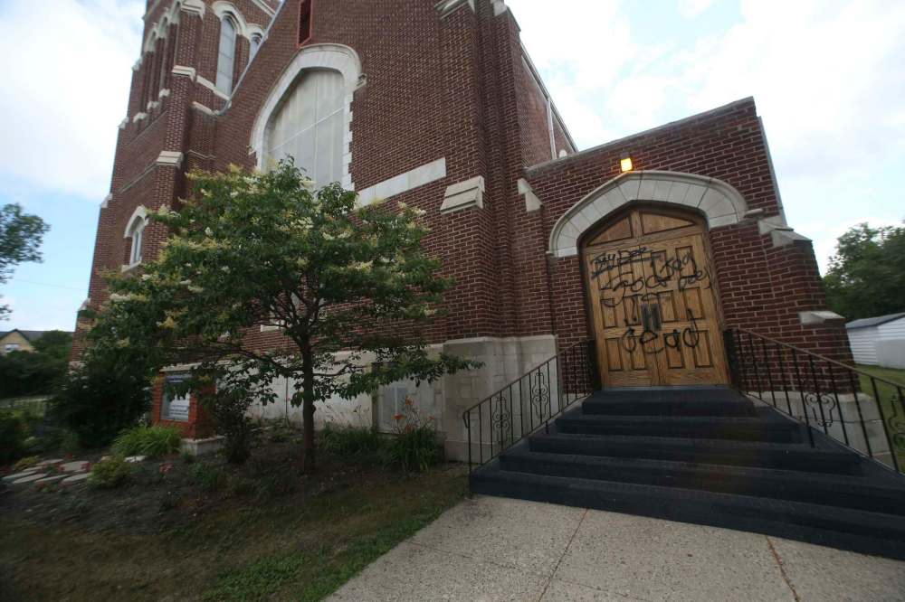 Black paint graffiti defaces the wooden front doors of the First Presbyterian Church in Brandon. (Matt Goerzen / The Brandon Sun)