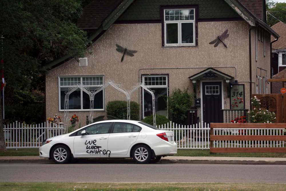 A car parked opposite the First Presbyterian Church is tagged with a message written in black paint. (Matt Goerzen / The Brandon Sun)