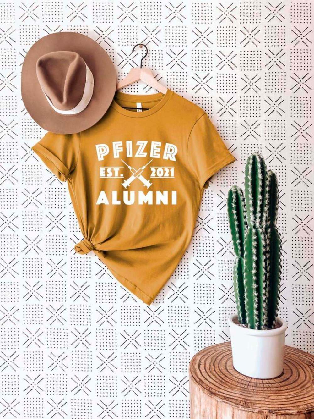 Online craft retailer Etsy is full of eye-catching pro-vaccination merch, such as this ‘Pfizer alumni’ T-shirt. (DoozyDoodle / Etsy)