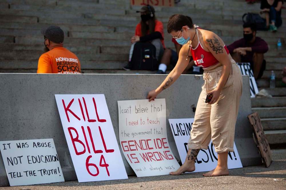 A protestor puts up a sign at the rally. The rally is part of an ongoing movement to oppose Bill 64, under the banner #ProtectEdMB. (Daniel Crump / Winnipeg Free Press)