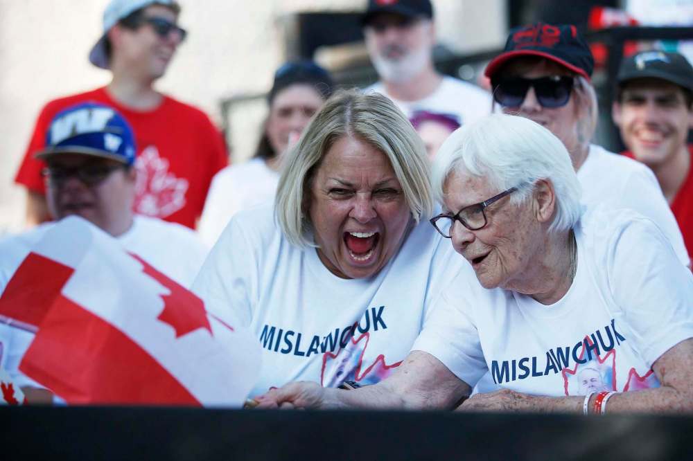 Family friend Kim Horrox (left) and Josephine Leddy, grandmother of Canadian triathlete Tyler Mislawchuk, cheer him on at his parents’ house in Oak Bluff. (John Woods / Winnipeg Free Press)