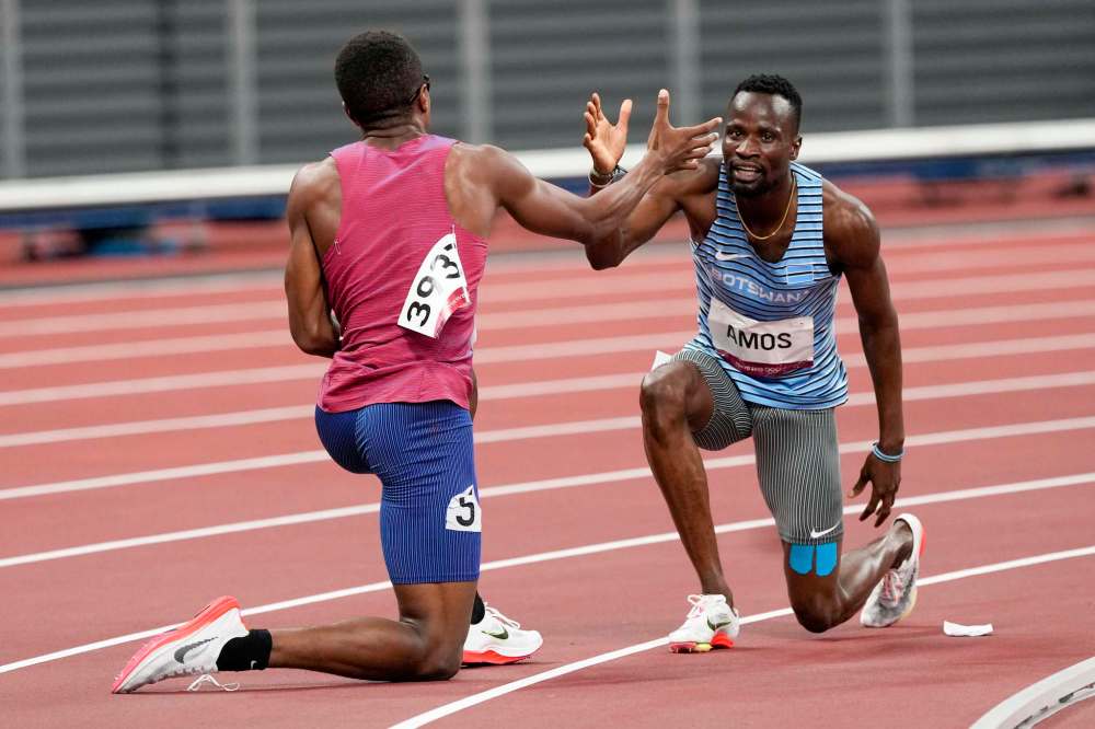 Isaiah Jewett, of the United States, and Nijel Amos, right, of Botswana, shake hands after falling in the men's 800-meter semifinal at the 2020 Summer Olympics, Sunday, Aug. 1, 2021, in Tokyo. (AP Photo/Jae C. Hong)