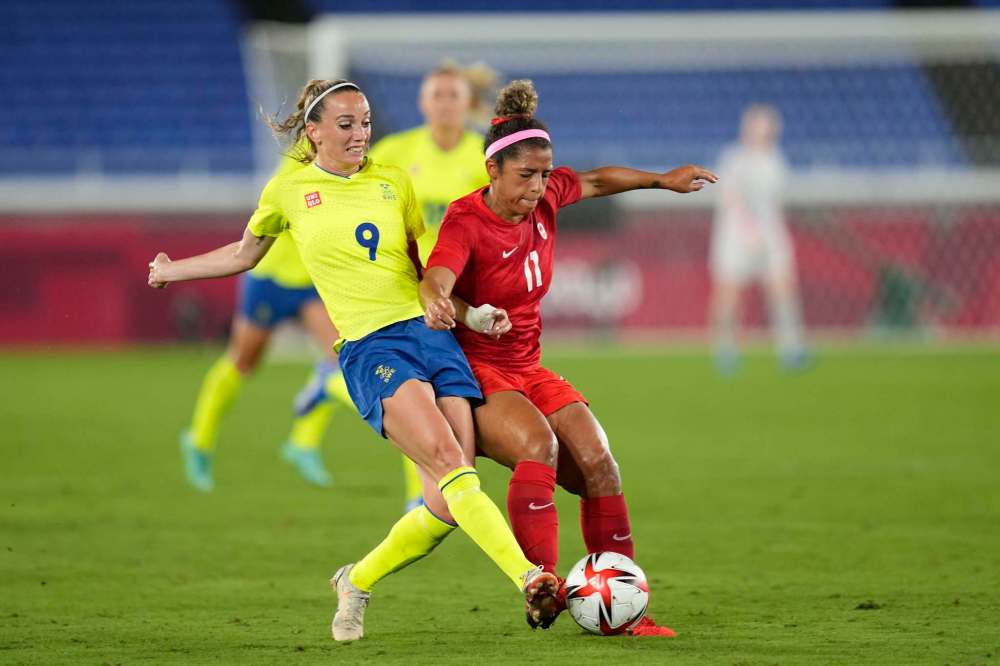Winnipeg’s Desiree Scott (right) and Sweden’s Kosovare Asllani battle Friday during the women’s final soccer match. (Andre Penner / The Associated Press)