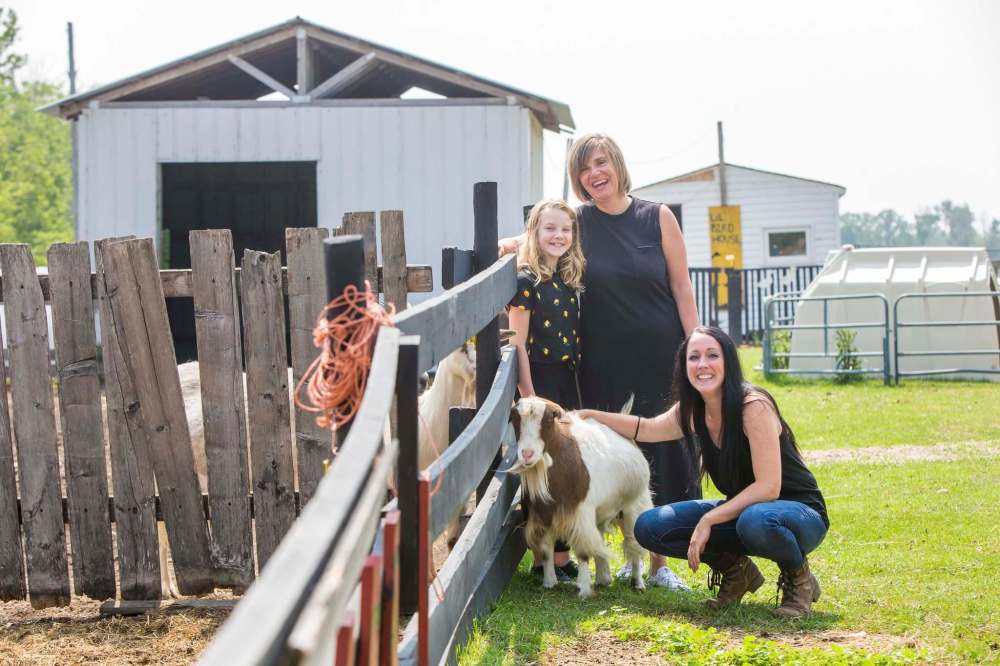 Macyn Comeault (left), Carissa Comeault, and Lucy Sloan, with Cindy the goat. (Mikaela MacKenzie / Winnipeg Free Press)