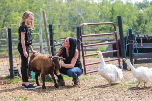 Macyn Comeault (left) and Lucy Sloan hang out with the animals at Lil&rsquo; Steps Wellness Farm in St. Malo. Sloan has been practicing animal-assisted therapy on her farm since 2015. (Mikaela MacKenzie / Winnipeg Free Press)