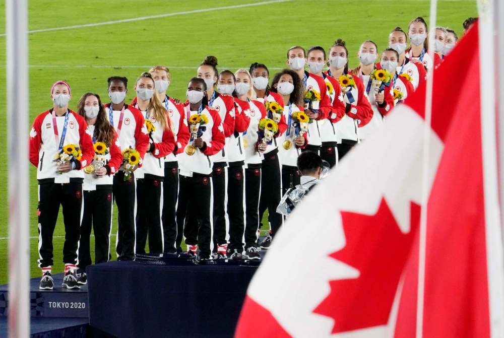 Frank Gunn / The Canadian Press
Canada stands for the national anthem as they celebrate their gold medals after defeating Sweden in the penalty shoot-out in the women's soccer final during the summer Tokyo Olympics Friday.