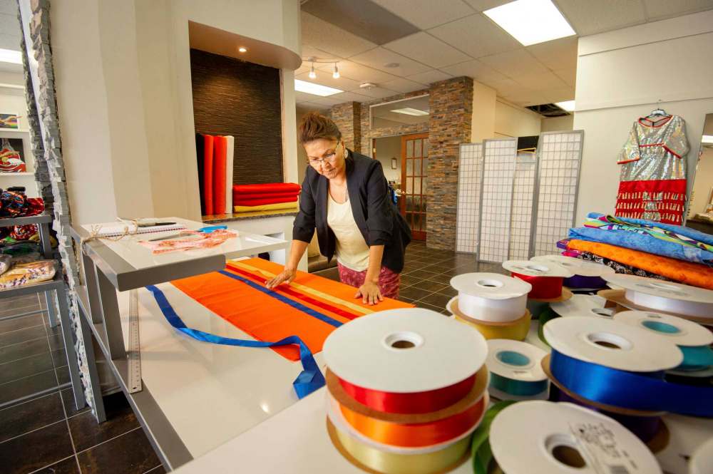 Tawipisim lays out the fabric for a popular traditional ribbon skirt. (Mike Sudoma / Winnipeg Free Press)