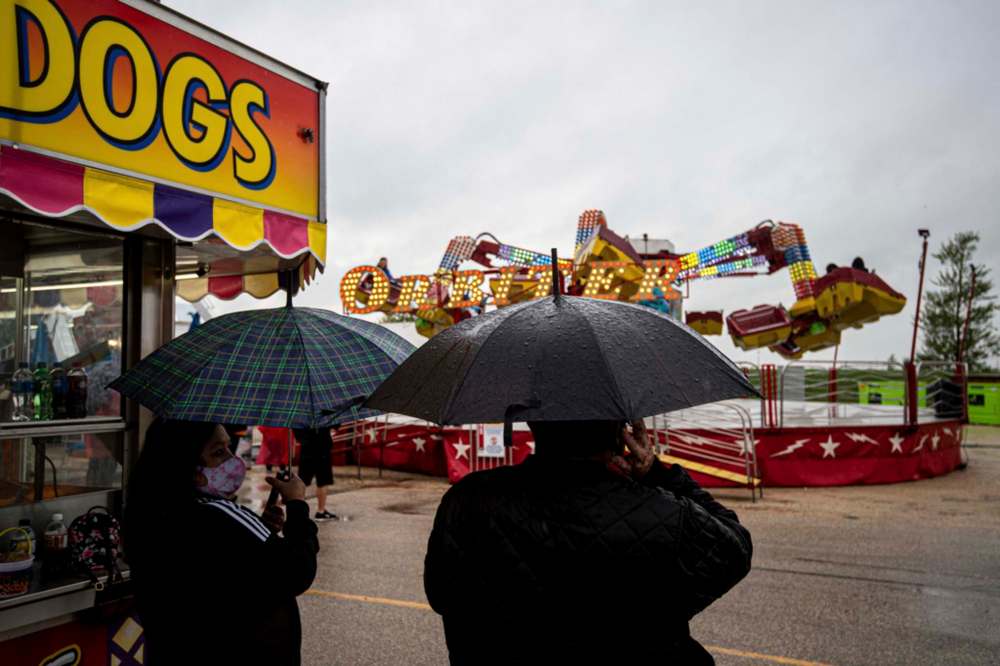 MIKE SUDOMA / Winnipeg Free Press
Attendees needed umbrellas to enjoy the Red River Exhibition’s Autumn Fair, Friday night.