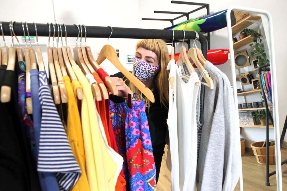 Kristen goes through a rack of vintage clothing. (Ruth Bonneville / Winnipeg Free Press)