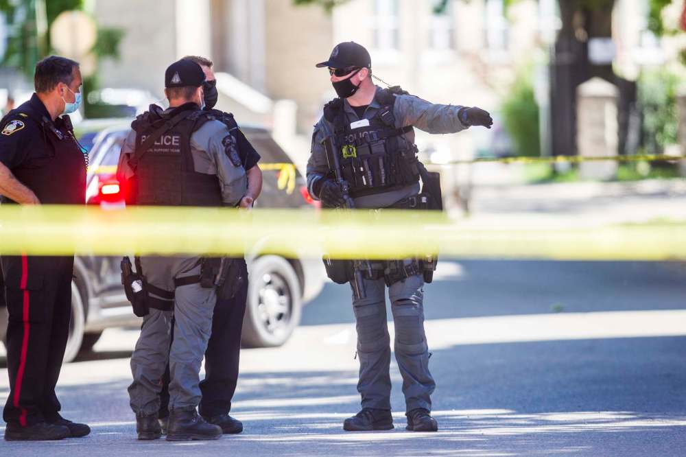 Police wear masks while investigating the scene of a shooting in central Winnipeg this summer. (Mikaela Mackenzie / Winnipeg Free Press files)