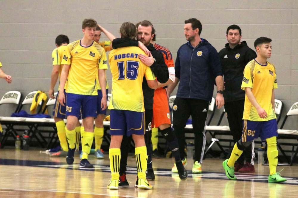 Jesse Roziere comforts a volleyball player after Brandon lost to the Canadian Mennonite University Blazers in the Manitoba Colleges Athletic Conference men’s final in 2020. (Perry Bergson/The Brandon Sun)