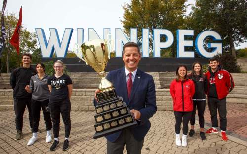MIKE DEAL / WINNIPEG FREE PRESS
Winnipeg mayor Brian Bowman holds the Duckworth Challenge trophy flanked by UofM Bisons athletes (from left) Owen Schwartz (men's volleyball), Jessica Tsai (soccer), and Taylor Randall (women's basketball), UofW Wesmen athletes, Chantal Boulet (soccer), Mikaela Cameron (women&rsquo;s volleyball), Darian Picklyk (men's volleyball). The 30th anniversary of the Duckworth Challenge kicks off later this week re-igniting the annual rivalry series between the two Winnipeg universities that now includes men's and women's basketball, men's and women's volleyball, and women's soccer.