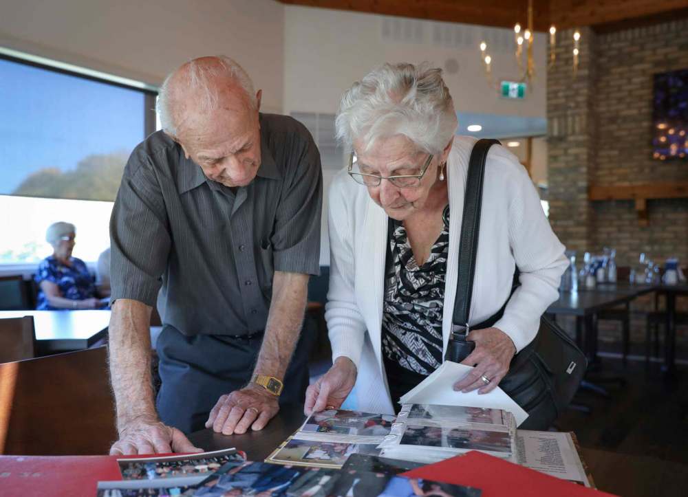 JESSICA LEE / WINNIPEG FREE PRESS
Martha Neufeld and John Sukkau look at photos of past get-togethers.