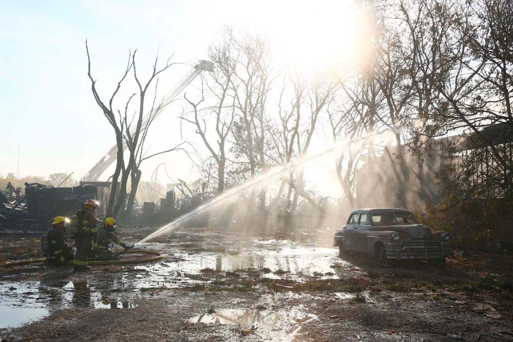 Firefighters work to extinguish hot spots from a warehouse fire in Point Douglas Wednesday. (Mike Deal / Winnipeg Free Press)