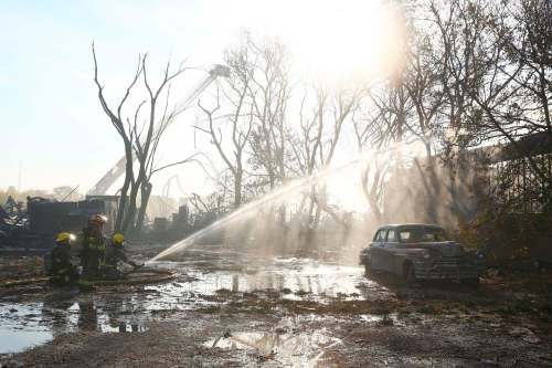 Firefighters work to extinguish hot spots from a warehouse fire in Point Douglas Wednesday. (Mike Deal / Winnipeg Free Press)