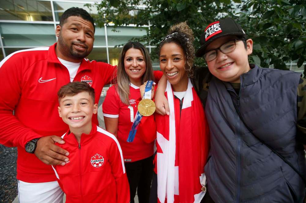 JOHN WOODS / FREE PRESS files
Desiree Scott is photographed with her brothers Nick, left, Deejay, right, and her sister-in-law Dina and nephew Kingston at the airport in Winnipeg after arriving from Tokyo.