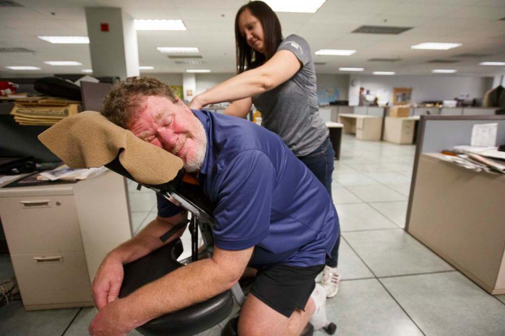 It wasn't all hard work. Here, Christy Cook from the Massage Therapy Association of Manitoba gives columnist Speirs a massage in the newsroom to promote therapeutic massage week in 2018. (Mike Deal / Winnipeg Free Press files)