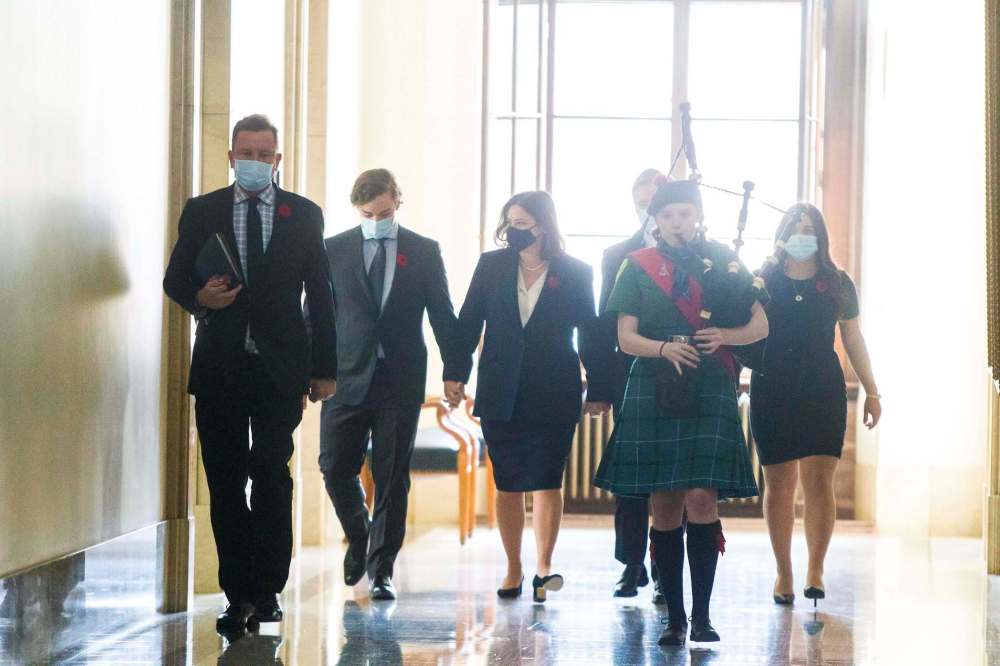 Heather Stefanson walks in to her swearing-in ceremony hand-in-hand with her family at the Manitoba Legislative Building in Winnipeg on Tuesday. (Mikaela MacKenzie / Winnipeg Free Press)