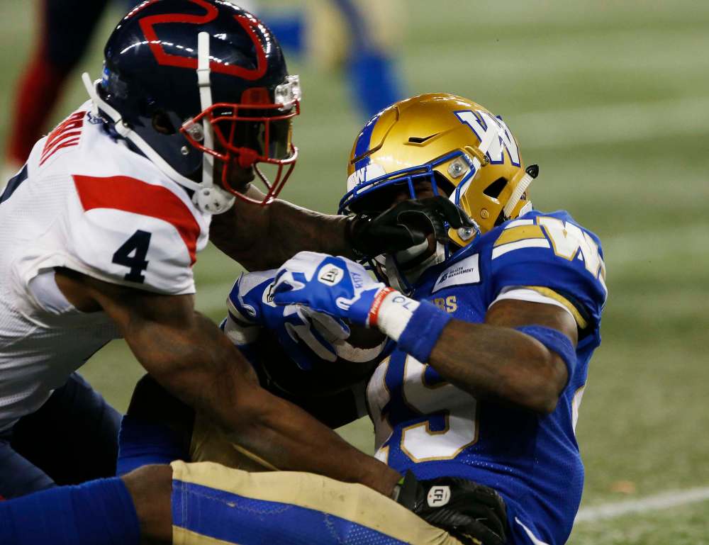 Winnipeg Blue Bombers' DeAundre Alford (45) intercepts a pass as Montreal Alouettes' Quan Bray (4) tackles him during the second half. (John Woods / The Canadian Press)