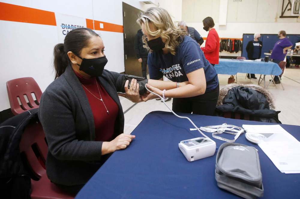 Kelly Lambkin, manager of community engagement for Diabetes Canada, tests the blood pressure of city councillor Devi Sharma as she attends the final in a series of mobile diabetes testing clinics put on by Canadian Diabetes at the Maples Community Centre in Winnipeg on Sunday. JOHN WOODS / WINNIPEG FREE PRESS