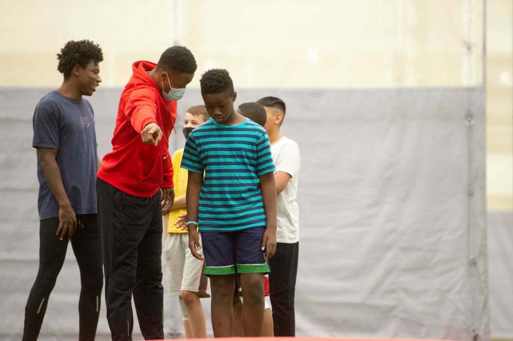 Mike Sudoma / Winnipeg Free Press
Rising Star founder Alhaji Mansaray gives attendee Tian Sakendu a few tips during a triple jump drill.