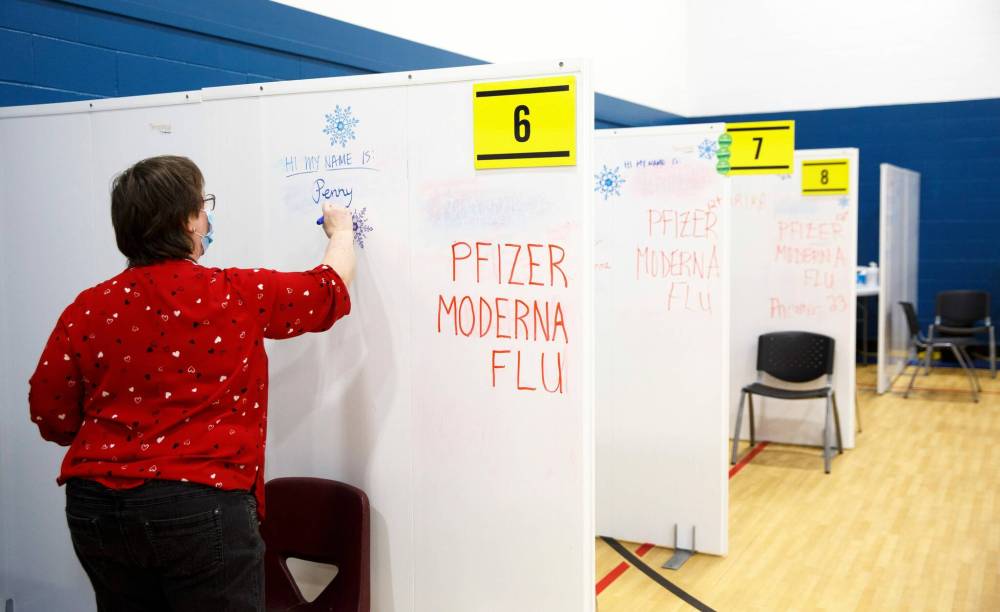 MIKE DEAL / WINNIPEG FREE PRESS Retired nurse, Penny Summers, writes her name on the wall of her cubicle before the vaccination clinic opens for the day Friday morning. Ma Mawi Wi Chi Itata Centre vaccine clinic at 363 McGregor Street, brings in a lot of community support and Indigenous tradition including a morning smudge of the vaccines. The atmosphere of togetherness and one-on-one support has helped many in the area who may be wary of getting the vaccine. See Melissa Martin story 220121 - Friday, January 21, 2022.