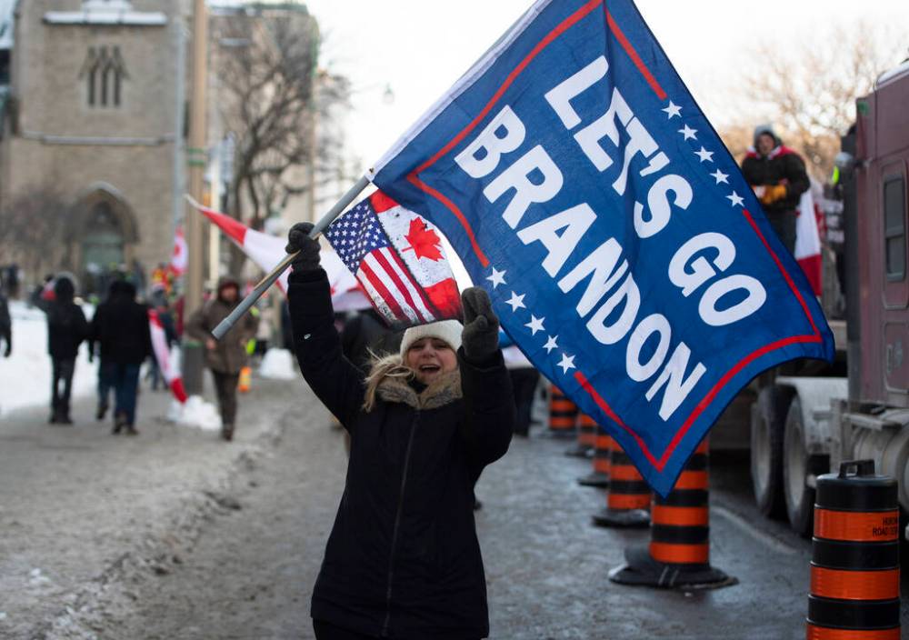 A person waves a “Let’s Go Brandon” flag, code for an expletive against U.S. President Joe Biden used by supporters of former U.S. President Donald Trump, during a rally against COVID-19 restrictions, which began as a cross-country convoy protesting a federal vaccine mandate for truckers, in Ottawa, on Saturday, Jan. 29, 2022. THE CANADIAN PRESS/Justin Tang