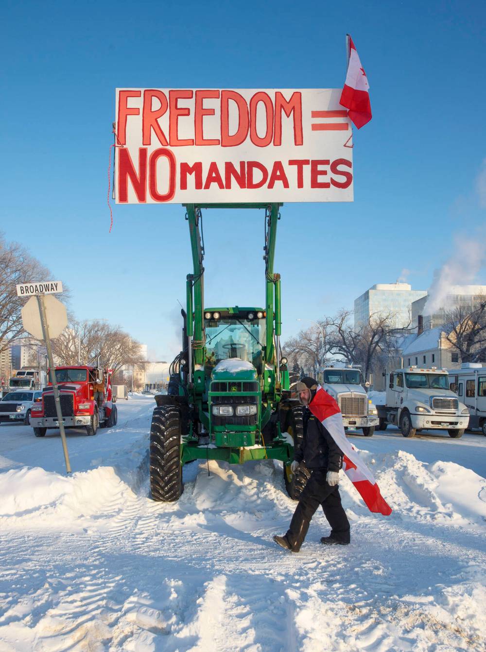 Protesters block the entrance to the Manitoba Legislative building on Broadway Avenue and have parked their trucks along Memorial early Friday morning. (Mike Deal / Winnipeg Free Press)