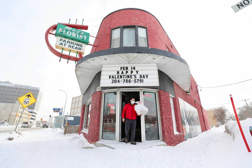 RUTH BONNEVILLE / WINNIPEG FREE PRESS ENT - Valentine’s florist Royճ Florist: 710 Notre Dame Photos for feature on local florist. Photo of customer, Carlos Zeballos, leaving store with gift. Royճ Florist is one of the oldest stores in the West End. It was opened in 1955 by Roy and Ron Kaita, taking the name of the elder brother as is the Japanese custom. Sixty-seven years later, and six years after Royճ death, that original sign still buzzes, and Royճ is as busy as ever with Valentineճ Day coming up. The shop is now owned by Debby Chan, a former customer who left the city for several years to work as an HR executive in Hong Kong. And, it is still staffed by Terri Holroyd who Ron Kaita hired in 1990. Before she and her husband were married, he sent Holroyd flowers Ѡto the store, from another store Ѡon Valentineճ Day. Holroyd promptly put them in the storeճ fridge and sold them to a new customer. Ben Waldman story. Feb 14, 2022