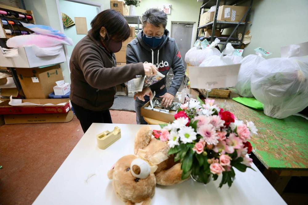 RUTH BONNEVILLE / WINNIPEG FREE PRESS ENT - Valentine’s florist Royճ Florist: 710 Notre Dame Photos for feature on local florist. Photo of Pamela Chan (left) and Williams Hau (Canada sweater) packaging up all the Valentine’s Day orders set to be delivered. Royճ Florist is one of the oldest stores in the West End. It was opened in 1955 by Roy and Ron Kaita, taking the name of the elder brother as is the Japanese custom. Sixty-seven years later, and six years after Royճ death, that original sign still buzzes, and Royճ is as busy as ever with Valentineճ Day coming up. Ben Waldman story. Feb 14, 2022