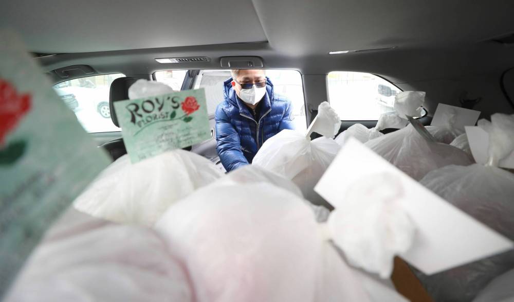RUTH BONNEVILLE / WINNIPEG FREE PRESS ENT - Valentine’s florist Royճ Florist: 710 Notre Dame Photos for feature on local florist. Photo of Chris Chan loading up packaged bouquets of Valentine’s Day orders that he is delivering. Royճ Florist is one of the oldest stores in the West End. It was opened in 1955 by Roy and Ron Kaita, taking the name of the elder brother as is the Japanese custom. Sixty-seven years later, and six years after Royճ death, that original sign still buzzes, and Royճ is as busy as ever with Valentineճ Day coming up. Ben Waldman story. Feb 14, 2022