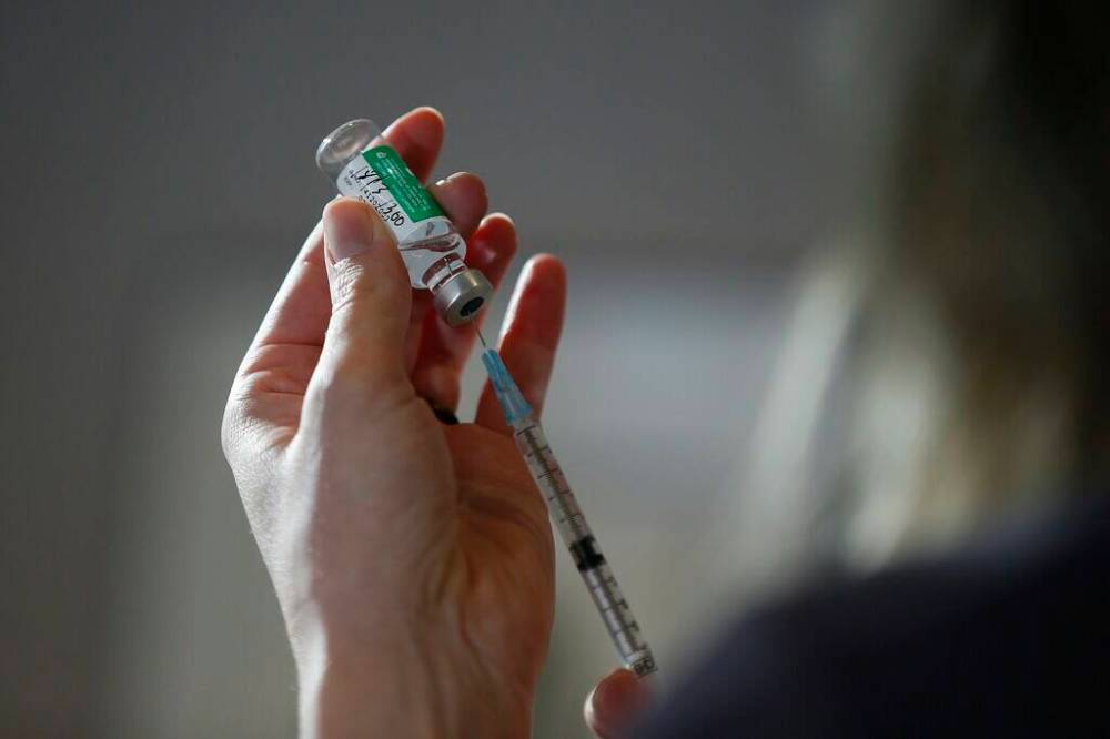 Dr. Joss Reimer, medical lead, Manitoba Vaccine Implementation Task Force draws a dose of the AstraZeneca COVID-19 vaccine at a clinic in Winnipeg, Friday, March 19, 2021. THE CANADIAN PRESS/John Woods