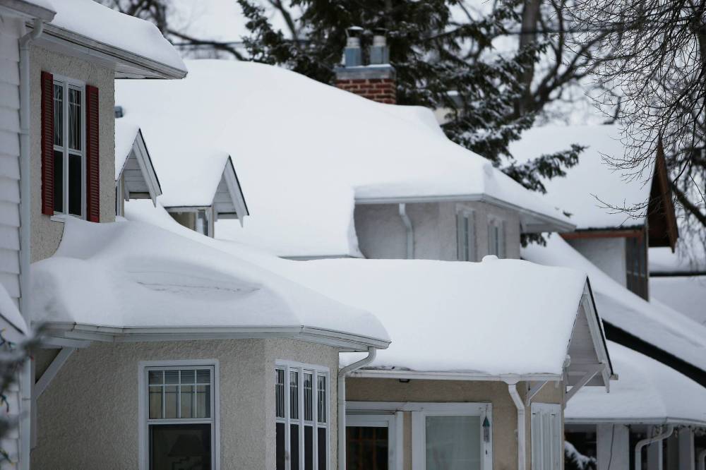 JOHN WOODS / WINNIPEG FREE PRESS
Growing accumulations of snow in Winnipeg can be seen on top of city homes Tuesday.