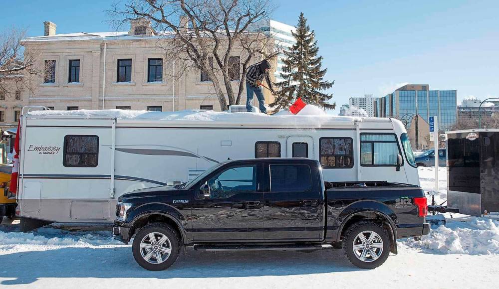 MIKE DEAL / WINNIPEG FREE PRESS
A protestor shovels snow off the roof of an RV.