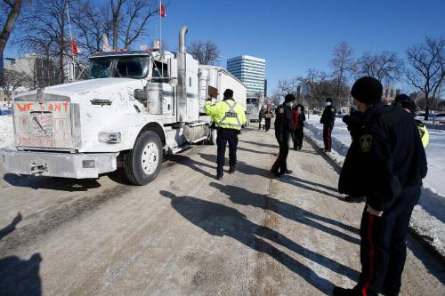 A Winnipeg police officer talks with the lead driver of a convoy of COVID-19 mandate protesters last week. (John Woods / Winnipeg Free Press files)