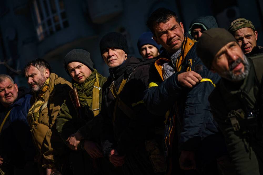Volunteers for Territorial Defence Units stand in formation, check their weapons, put on yellow armbands, get marching orders and ship out to their posts to defend the city from the Russian invasion, in Kyiv, Ukraine, Monday, Feb. 28, 2022. (Marcus Yam / Los Angeles Times / TNS)