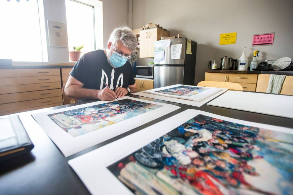 MIKAELA MACKENZIE / WINNIPEG FREE PRESS
Local artist Michael Boss signs prints of his 2014 work Ukrainian Kozaks Send a Letter to Putin at Martha Street Studios.