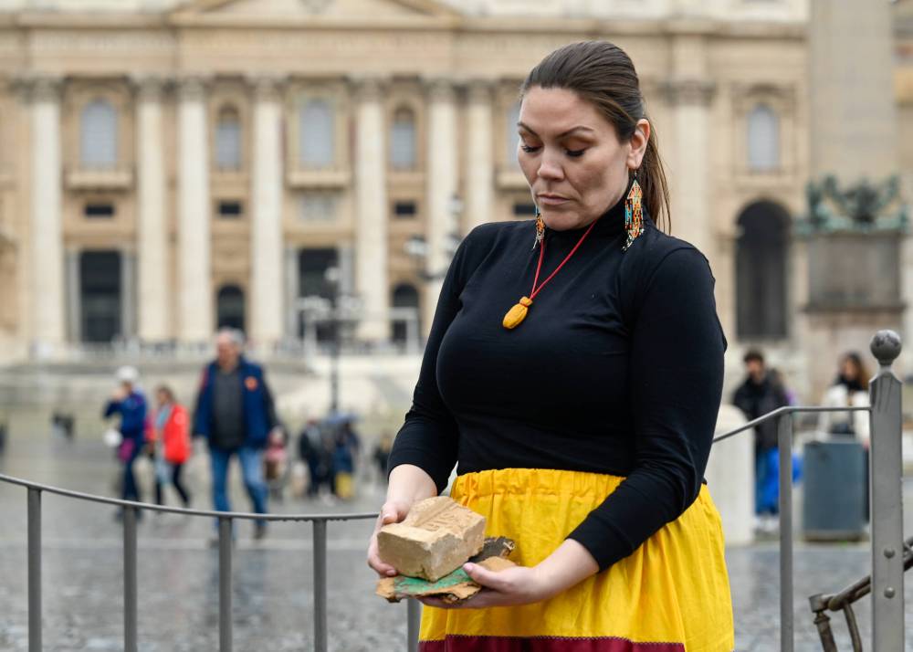 Jade Harper holds a brick from the former Brandon residential school attended by her grandmother and other relatives while in Rome this week. Jade Harper, a member of Peguis First Nation, came to Rome to help make a documentary about the First Nations delegation to see the Pope, she knew what she needed to bring. (Fred Cattroll)