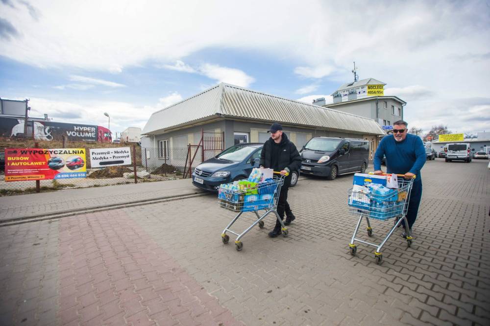 MIKAELA MACKENZIE / WINNIPEG FREE PRESS
Volunteers Bradley Taylor (left, from Britain) and Art Ballard (from California) push shopping carts full of items to drop off at the border, which will be taken into Ukraine.