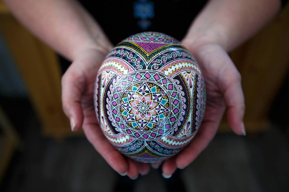 Rossier holds an ostrich egg that took around 100 hours to decorate.