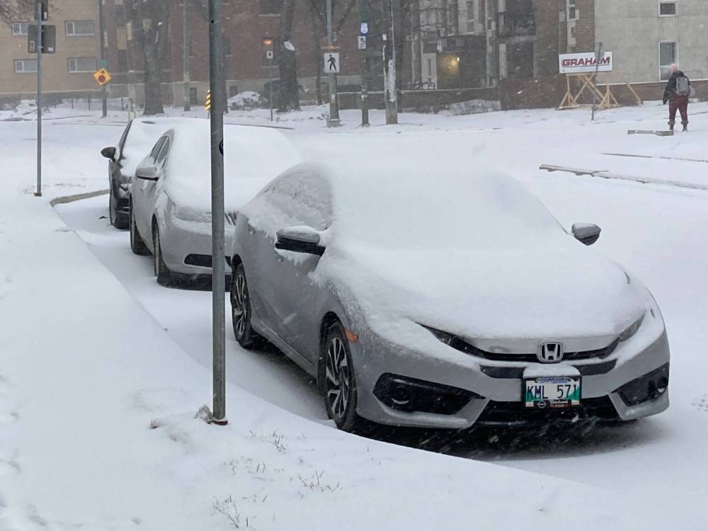Snow covers cars parked on Balmoral Street in West Broadway early Wednesday morning. (Winnipeg Free Press)