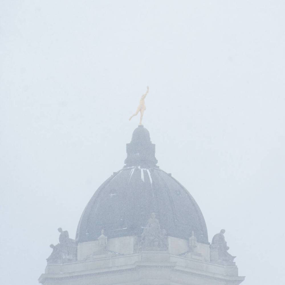 The Golden Boy statue stands tall, but barely visible atop the Manitoba Legislative Building in Winnipeg, Wednesday, during a spring snowstorm. THE CANADIAN PRESS/Mike Sudoma
