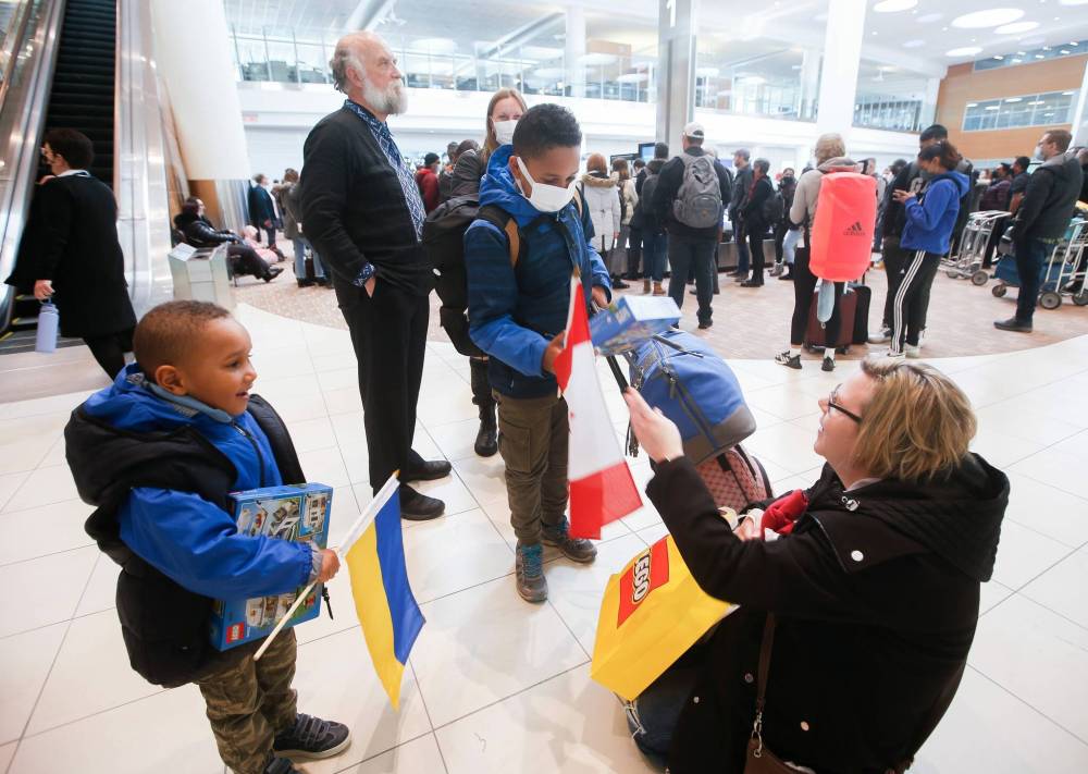 JOHN WOODS / WINNIPEG FREE PRESS Viktoriia Katsol and Christian Anayo Egwuom with their children Davyd, 9, and Filip, 4, arrive from Ukraine and are welcomed to Winnipeg by Taras Maluzynsky (left background) of the Ukrainian Canadian Congress and Aniela Hannaford (right), owner of Brown’s Clearwater West Lodge in Atikokan, Ont. Hannaford has opened her lodge to people escaping the Russian invasion.