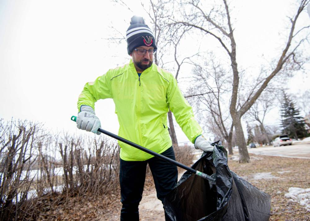 Mike Sudoma / Winnipeg Free Press Custodian and plogging enthusiast Tim Coombs picks up trash while out for a jog on his lunch break.