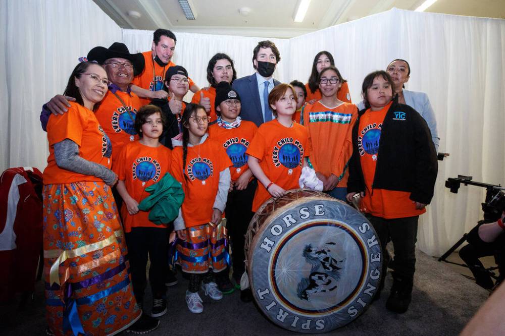 MIKE DEAL / WINNIPEG FREE PRESS Prime Minister Trudeau gets his photo taken with the Spirit Horse Singers after the ceremony. The Southern Chiefs Organization took posession of the downtown Winnipeg, Hudson’s Bay Co. building during a two-hour ceremony Friday morning, which was attended by Prime Minister Trudeau, Manitoba Premier Heather Stefanson, Southern Chiefs’ Organization Grand Chief, Jerry Daniels, HBC Governor, Richard Baker, Ahmed Hussen, Minister of Housing and Diversity and Inclusion, Patty Hajdu, Minister of Indigenous Services Canada, and Dan Vandal, Minister of Northern Affairs and Minister responsible for Prairies Economic Development Canada. The vacant six-storey building, which opened in 1926 was closed in November 2020. 220422 - Friday, April 22, 2022.