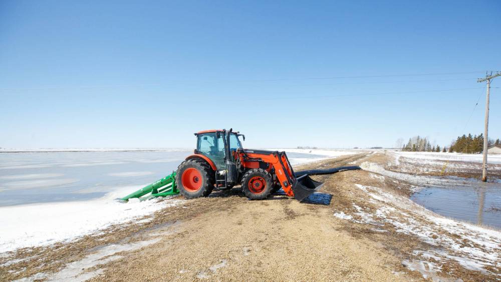 MIKE DEAL / WINNIPEG FREE PRESS
A tractor keeps a pump running as it removes water from a farmer’s field into Wavey Creek close to Sutherland Road and Highway 8, Tuesday afternoon.