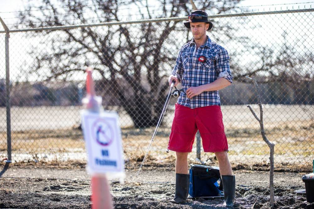 Chris Thompson had no trouble reeling in the laughs when he cast a fishing line into a giant pothole on Route 90 Wednesday. (Mikaela MacKenzie / Winnipeg Free Press)
Thompson cast a lure into the depths of a sizable pothole