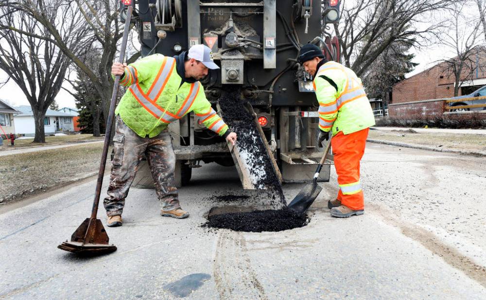 RUTH BONNEVILLE / WINNIPEG FREE PRESS
Street work City crews fill potholes with a tar mixture along Burrows Ave. It was unclear how many calls involved pothole damage because CAA Manitoba doesn’t track the statistic.