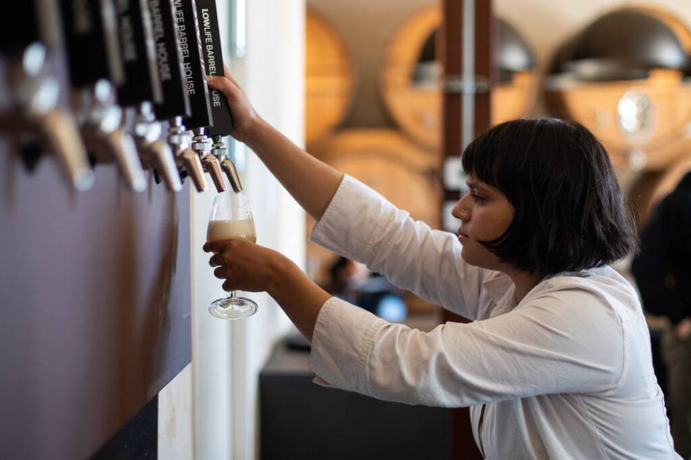 DANIEL CRUMP / WINNIPEG FREE PRESSAllison Carrasco pours a drink while working on opening day of Low Life Barrel House.